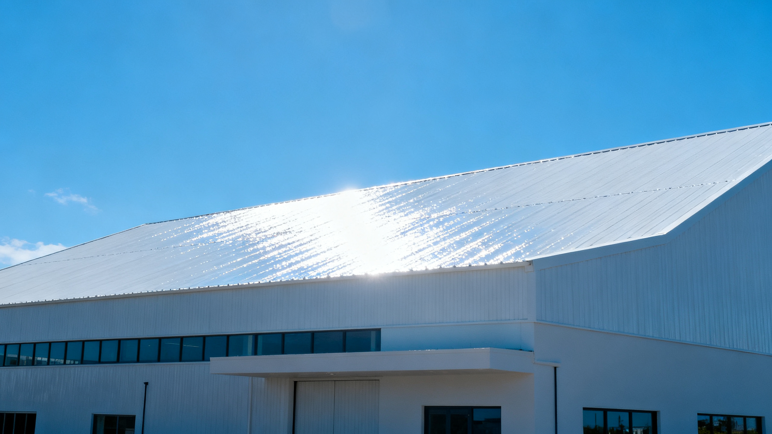 Bâtiment avec toiture blanche réfléchissante sous le soleil